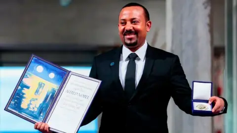 Getty Images Ethiopia's Prime Minister and Nobel Peace Prize Laureate Abiy Ahmed Ali poses after he was awarded the Nobel Peace Prize during a ceremony at the city hall in Oslo on December 10, 2019