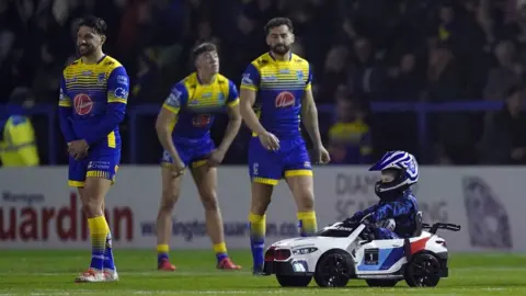 PA Media Whizzy Rascal and Warrington Wolves players