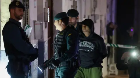 MARISCAL/EPA The confessed murderer of three brothers from Morata de Tajuna, Dilawar Hussein F.C. (R), is escorted by Spanish Civil Guard during a register in his home in Arganda del Rey, Madrid, Spain, 22 January 2024