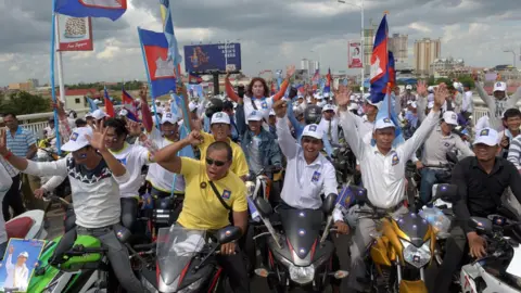 AFP CNRP supporters cheering with flags during a rally