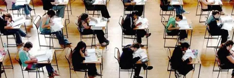 Pupils at desks in exam room