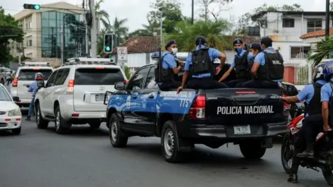 Reuters Police officers escort the vehicle of Felix Maradiaga in Managua