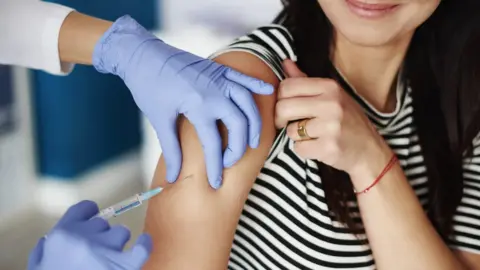 Getty Images woman getting injection in her upper arm