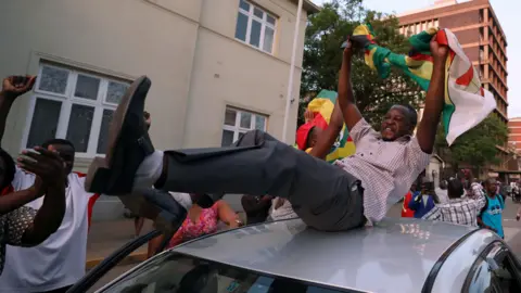 Reuters Man on car in Harare