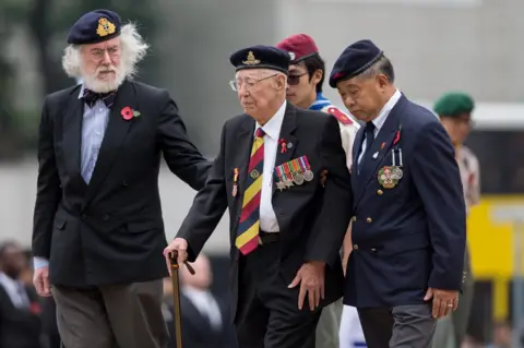 EPA Hong Kong veterans walk after laying wreaths in front of the Cenotaph in Hong Kong, China,
