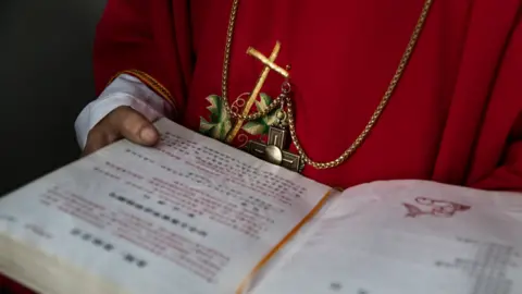 Getty Images A Chinese Catholic deacon holds a bible at the Palm Sunday Mass during the Easter Holy Week, 19 April 9 2017