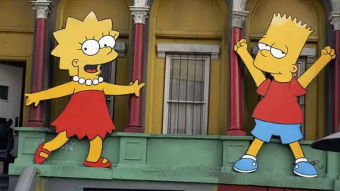 Getty Images Lisa Simpson and Bart Simpson cut-outs on display at 'The Simpsons' 350th episode block party on the New York street of Fox Pico Lot on April 25, 2005 in Los Angeles, California.