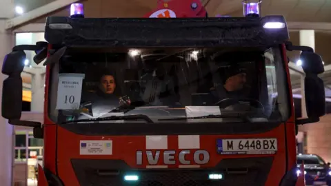 Getty Images Two men in a fire truck pass a border check