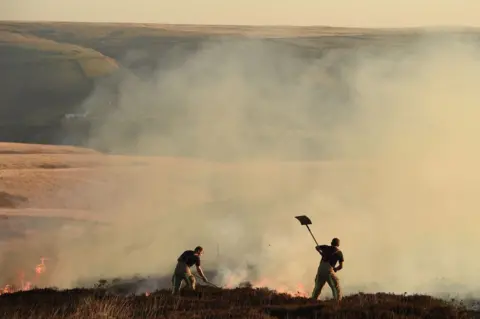 Getty Images Firefighters at moorland fire near Marsden