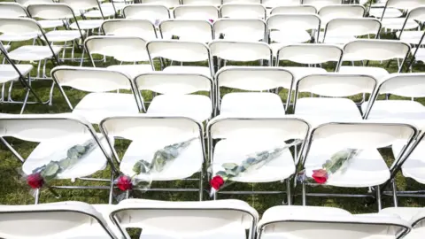 EPA White chairs and red roses are set up by relatives of crash victims of flight MH17 as a silent protest in front of the Russian embassy in The Hague, The Netherlands, 8 May 2018
