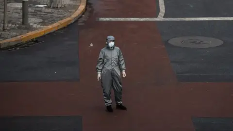 Getty Images A Chinese woman wears a protective suit in Beijing