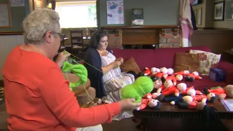 Yarn Bombers with their knitted dolls