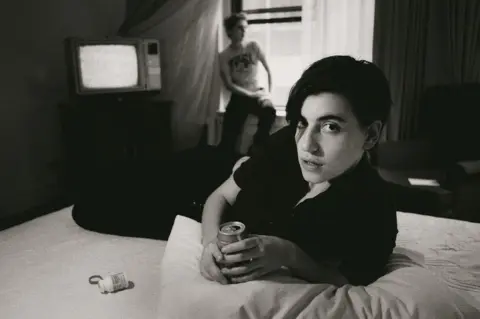 Kevin Cummins Elastica's Justine Frischmann on a hotel bed drinking a can of lager