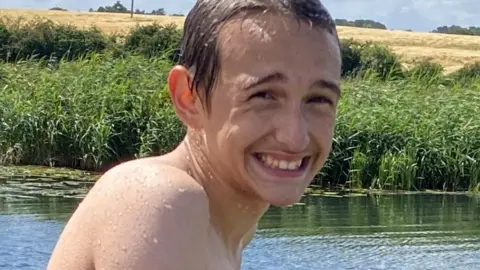 Family Photo Alfie smiling while playing in a river