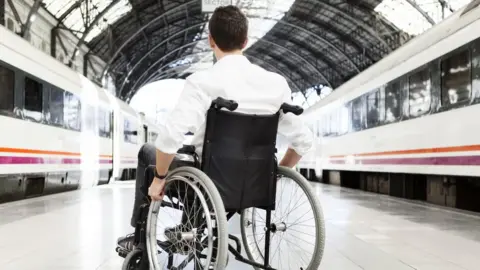 Getty Images Man in wheelchair at train station