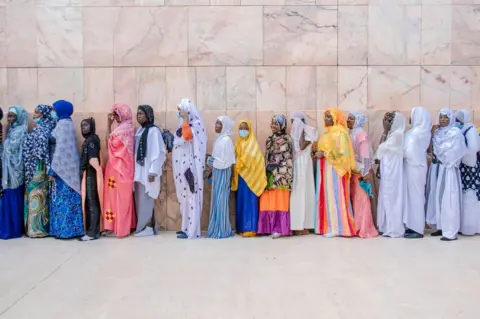 Carmen Abd Ali / AFP Mourides pilgrims line up to enter the Great Mosque of Touba during the Grand Magal in Senegal on 26 September 2021