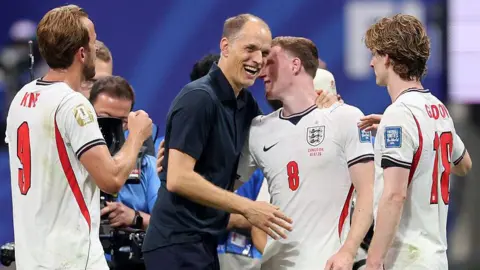 Getty Images Thomas Tuchel embraces England players at the end of a World Cup game.