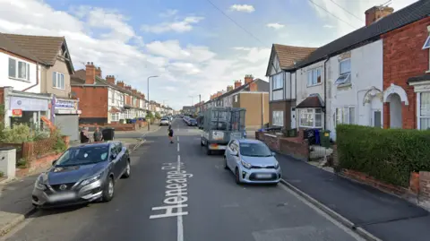A google maps image looking down Heneage towards the junction where the collision happened.  It is a residential street with some local shops on the corner of the junction.