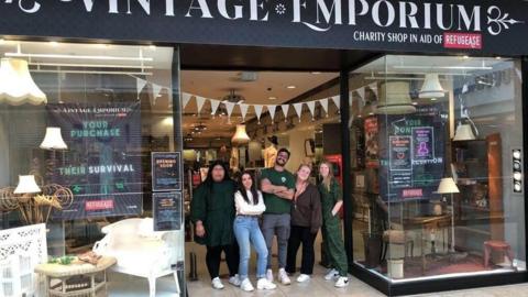 Founders and volunteers for Refugease gather in the doorway of one of the charity's "Vintage Emporium" shops in Tunbridge Wells