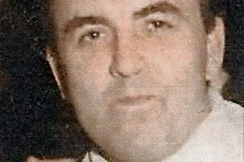 PA Media A colour photograph of Joe Lynskey. He has short dark brown hair and is looking directly to camera with his mouth closed. He is also wearing a light coloured shirt.