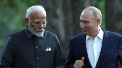 AFP In this pool photograph distributed by the Russian state agency Sputnik, Russia's President Vladimir Putin and Indian Prime Minister Narendra Modi take a walk during an informal meeting at the Novo-Ogaryovo state residence, outside Moscow, on July 8, 2024