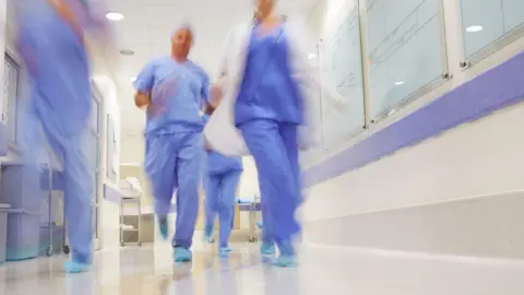 Blurred image of medical staff running through the hospital corridors. (stock photo)