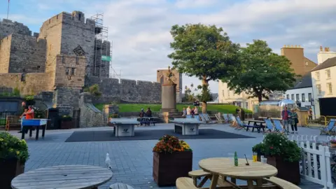 Market Square, with Castle Rushen in the background. There are ping pong tables and deck chairs placed in the square.