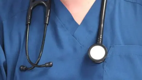 PA Stock image of doctor wearing blue tunic with stethoscope around their neck