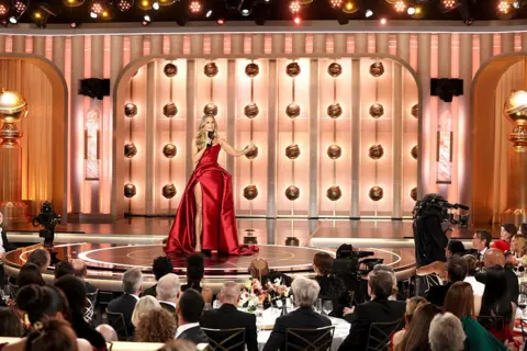 La presentatrice di Getty Images Nikki Glaser indossa un abito rosso mentre parla sul palco durante l'83° Golden Globe Awards al Beverly Hilton l'11 gennaio 2026 a Beverly Hills, California.