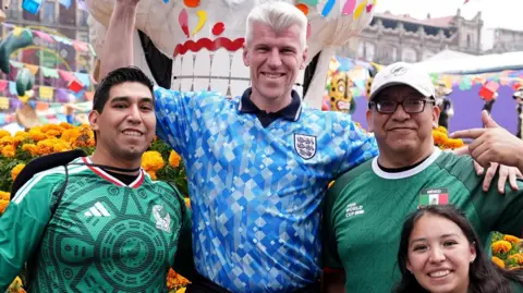 PA Media An England fan poses for a picture with Mexico fans in Plaza de la Constitucion, Mexico City. England face Mexico in their FIFA World Cup 2026 round of 16 match on Monday.