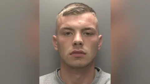 Humberside Police Custody picture of Lance Kinsley taken in prison. He is wearing a grey top and is looking straight at the camera