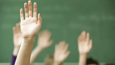 Getty Images hands up in class