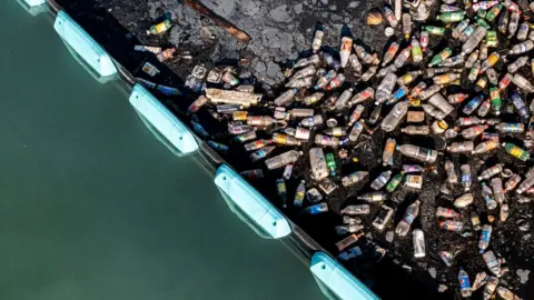 The Ocean Cleanup Plastic bottles pile up behind the Ocean Cleanup's Interceptor barrier in Kingston Harbour, Jamaica
