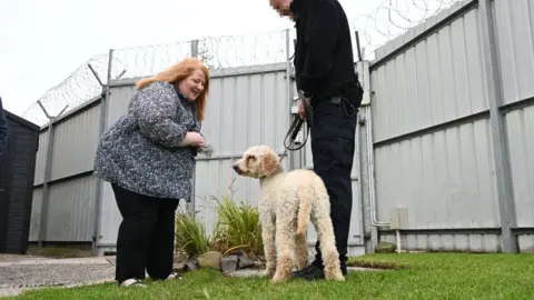 Michael Cooper Justice Minister Naomi Long meets one of the Northern Ireland Prison Service dogs and its handler at Maghaberry Prison