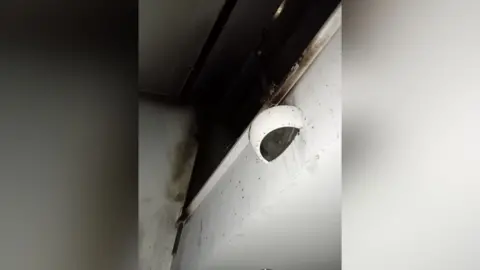 Jemima Staddon A white wall, mostly burned black from fire.