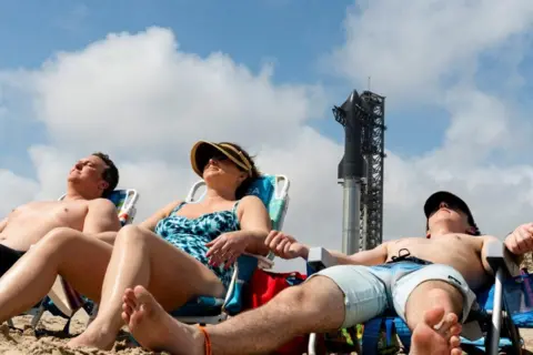 CHENEY ORR / REUTERS A family from Colorado sunbathes ahead of a SpaceX rocket launch