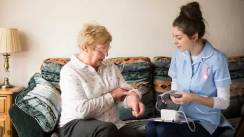 Getty Images Health check by nurse with elderly patient