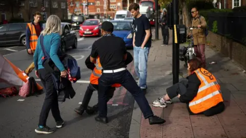 Reuters Members of the public remove activists from a road during a Just Stop Oil protest in London