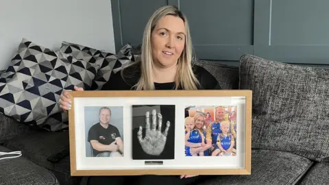 BBC Janet holds up a memorial photo frame of her fiancé Paul