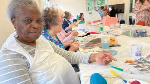 Wendy Brown sitting at a table and painting