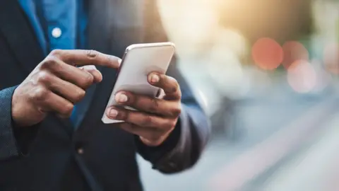 Getty Images Man holding phone