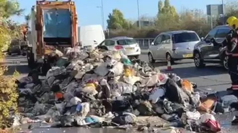 Cambridgeshire Fire and Rescue Rubbish bags all over the road, emptied from a bin lorry that caught fire.