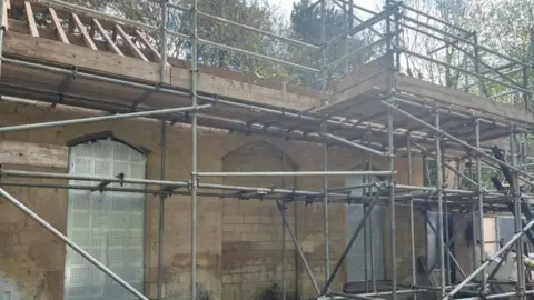 Emma Baugh/BBC Scaffolding surrounds the station