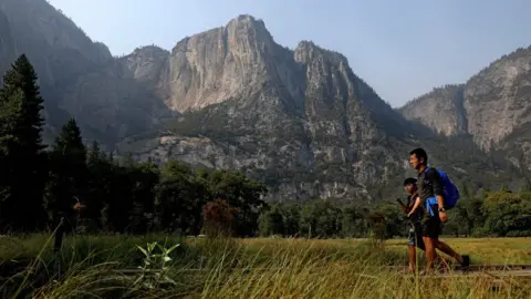 Getty Images Visitors walk past Columbia Rock in Cook's Meadow in Yosemite Valley, Yosemite National Park