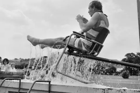 Historic England/John Laing Collection Director being dunked into pool in chair