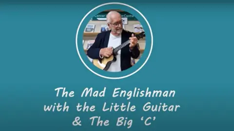 Northants Cancer Information Hub Man with very short hair and short grey beard playing a ukulele with the caption "the mad Englishman with the little guitar and the Big C"