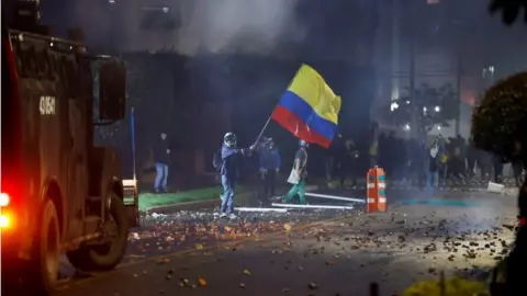 EPA Members of the Mobile Anti-Riot Squad (ESMAD) confront protesters who arrive in the neighborhood where the President of Colombia Ivan Duque has his residence, during a day of protests against the tax reform, in Bogota, Colombia, 01 May 2021.