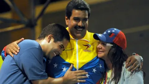 Getty Images President Nicolas Maduro embraces his wife Cilia Flores and son Nicolas Maduro during a 2013 campaign rally