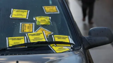 PA File image showing parking tickets on a windscreen