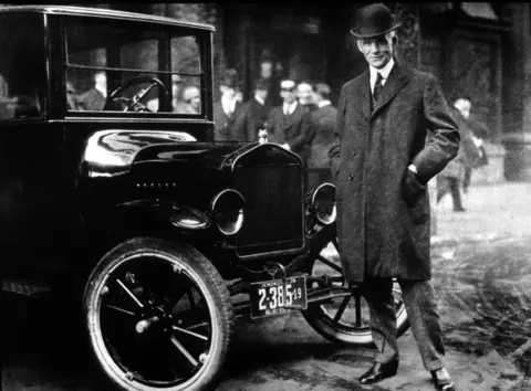 Getty Images Henry Ford with one of his Model T cars, pictured in the 1930s